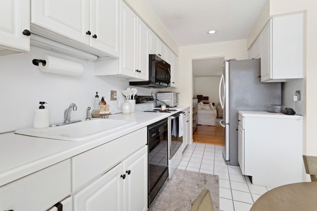 108 Abington Road, Unit 108 Danvers, MA 01923 - Photo 7 of 34 a kitchen with a sink stainless steel appliances a refrigerator a stove and cabinets