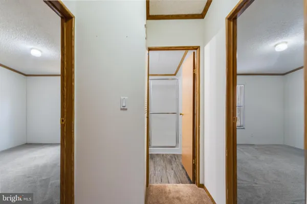 a view of a hallway with wooden floor and a living room