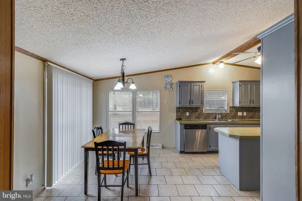 a kitchen with stainless steel appliances granite countertop a stove a sink dishwasher a dining table and chairs with wooden floor