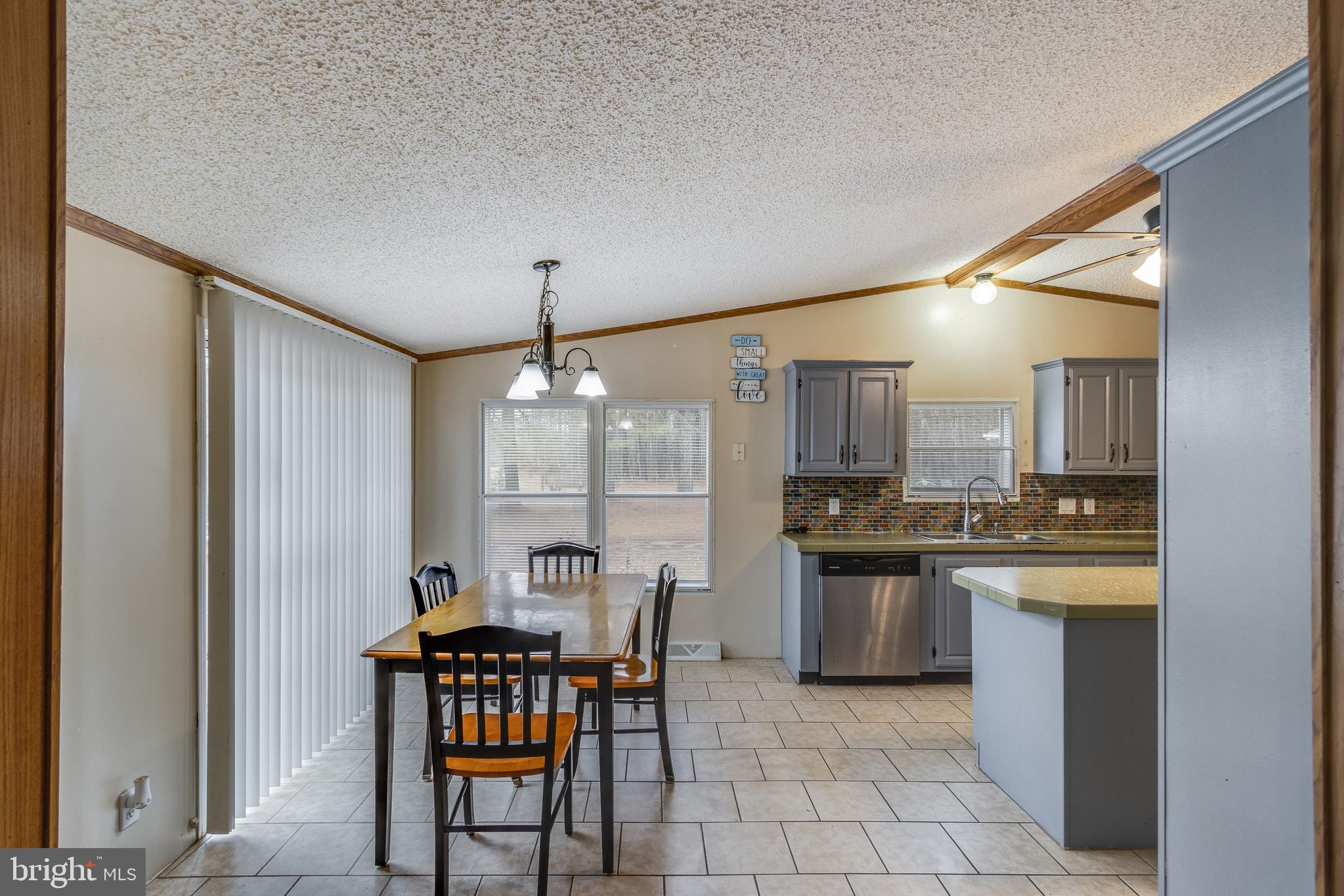 2578 Williamsville Road Houston, DE 19954 - Photo 29 of 52 a kitchen with stainless steel appliances granite countertop a stove top oven a sink a dining table and chairs
