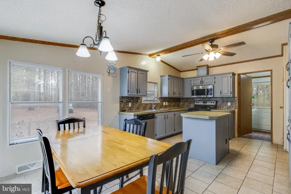 a kitchen with kitchen island granite countertop a sink counter top space appliances and cabinets
