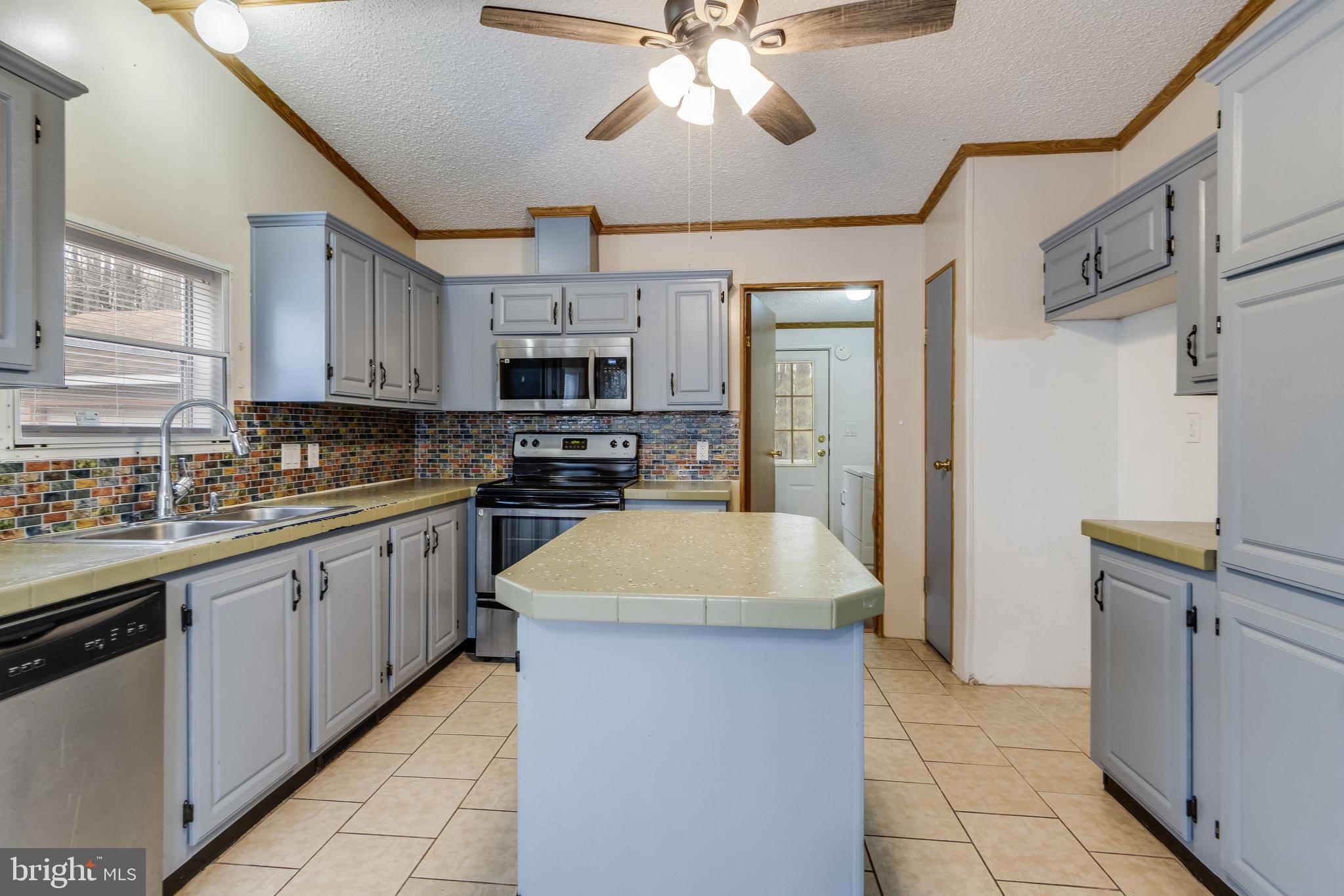2578 Williamsville Road Houston, DE 19954 - Photo 32 of 52 a kitchen with kitchen island granite countertop a sink counter top space appliances and cabinets