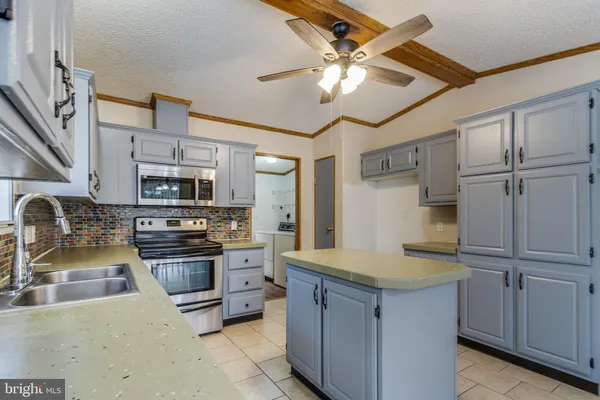 a kitchen with kitchen island a sink appliances and cabinets
