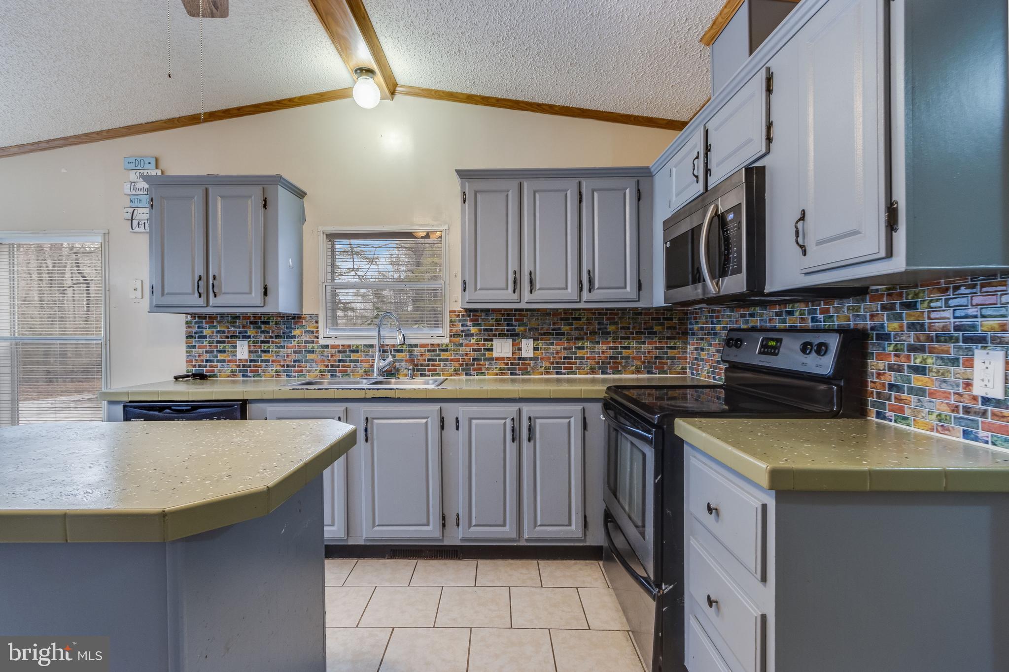 2578 Williamsville Road Houston, DE 19954 - Photo 38 of 52 a kitchen with stainless steel appliances granite countertop a sink a stove and cabinets