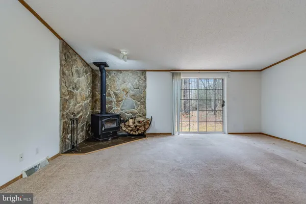 a view of an empty room with furniture and a window