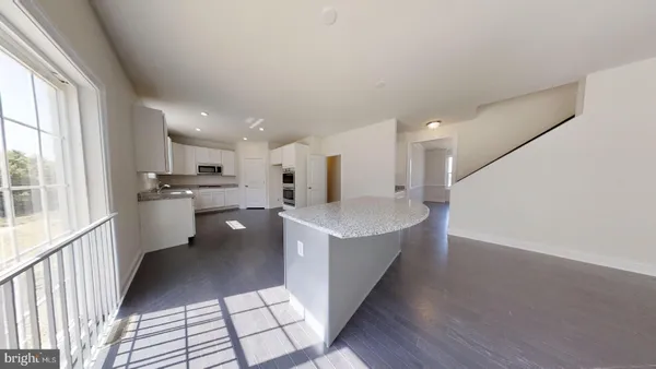 a view of a kitchen with a sink stove cabinets and empty room