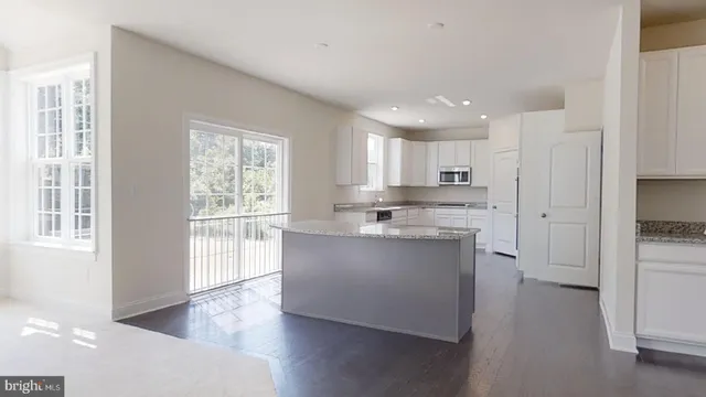 a kitchen with stainless steel appliances a stove and white cabinets