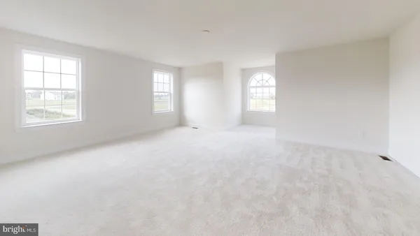 an empty room with wooden floor and mirror
