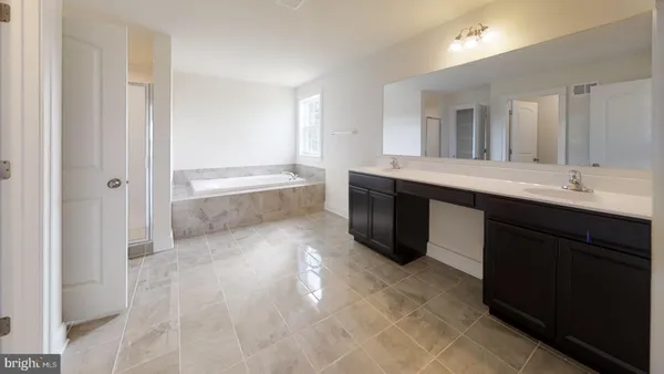 a en suite bathroom with a granite countertop sink and a mirror