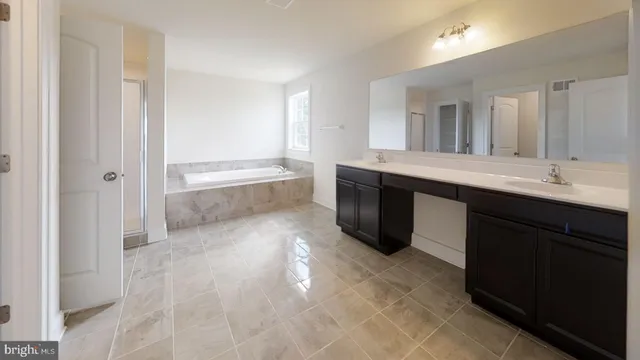 a en suite bathroom with a granite countertop sink and a mirror