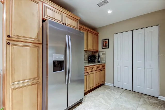 a kitchen with stainless steel appliances granite countertop a refrigerator and a refrigerator