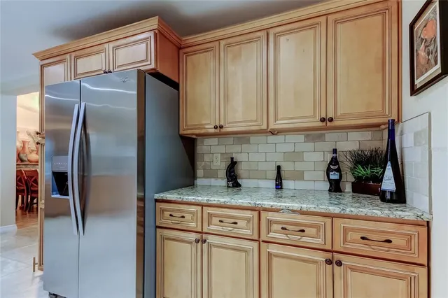 a kitchen with granite countertop a refrigerator sink and cabinets