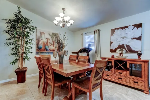 a dining room with furniture potted plants and wooden floor