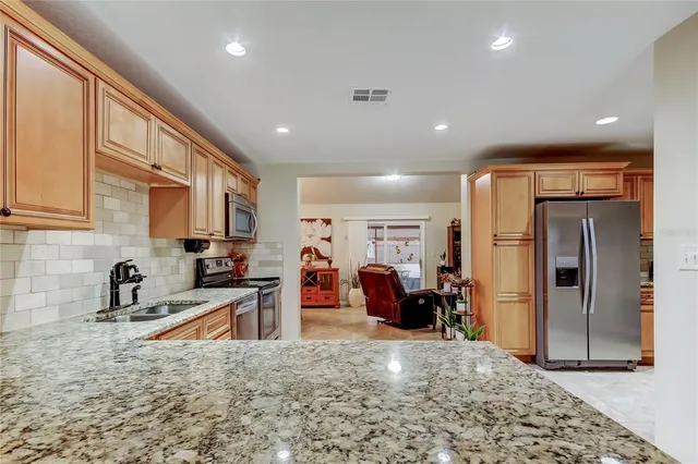 a kitchen with stainless steel appliances granite countertop a refrigerator and a sink