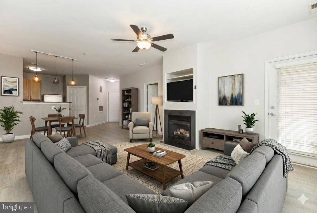 22664 Blue Elder Terrace, Unit 102 Brambleton, VA 20148 - Photo 1 of 25 a living room with furniture and a fireplace