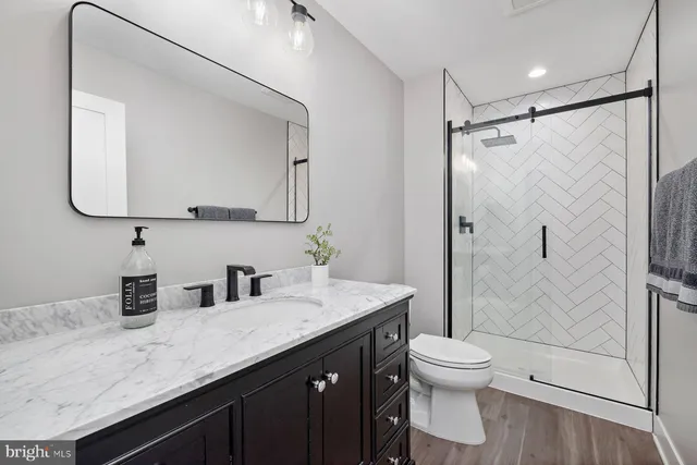 a bathroom with a granite countertop sink toilet and shower