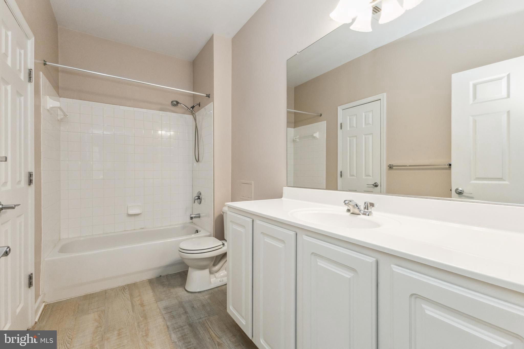 22664 Blue Elder Terrace, Unit 102 Brambleton, VA 20148 - Photo 14 of 25 a bathroom with a sink a toilet and shower