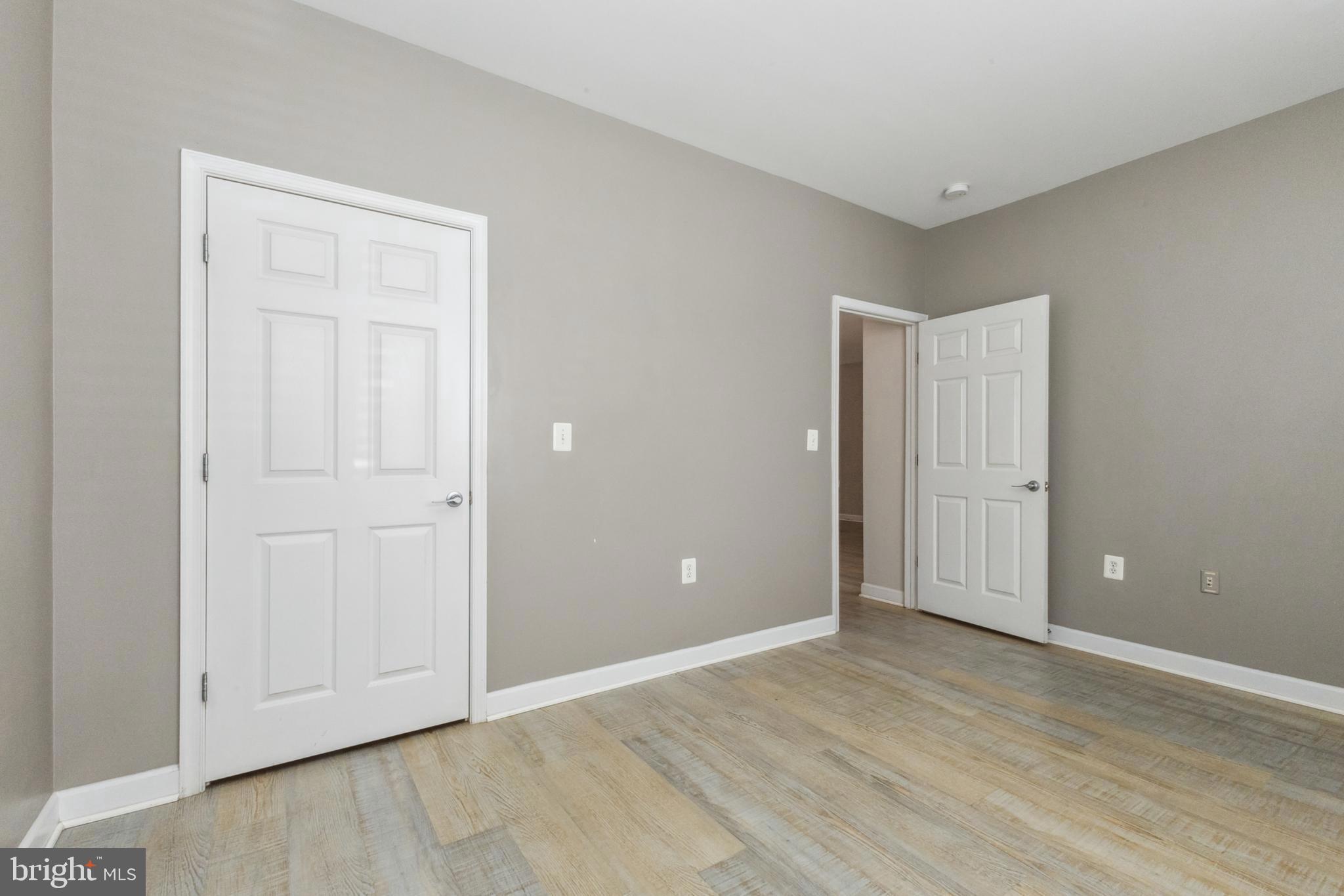 22664 Blue Elder Terrace, Unit 102 Brambleton, VA 20148 - Photo 18 of 25 a view of an empty room with wooden floor