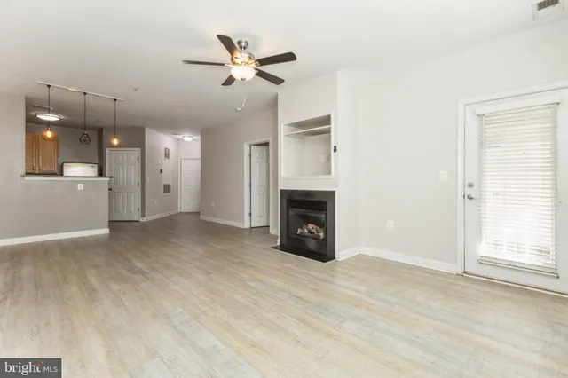 an empty room with windows and fireplace