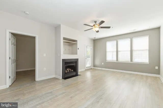 a view of empty room with fireplace and wooden floor