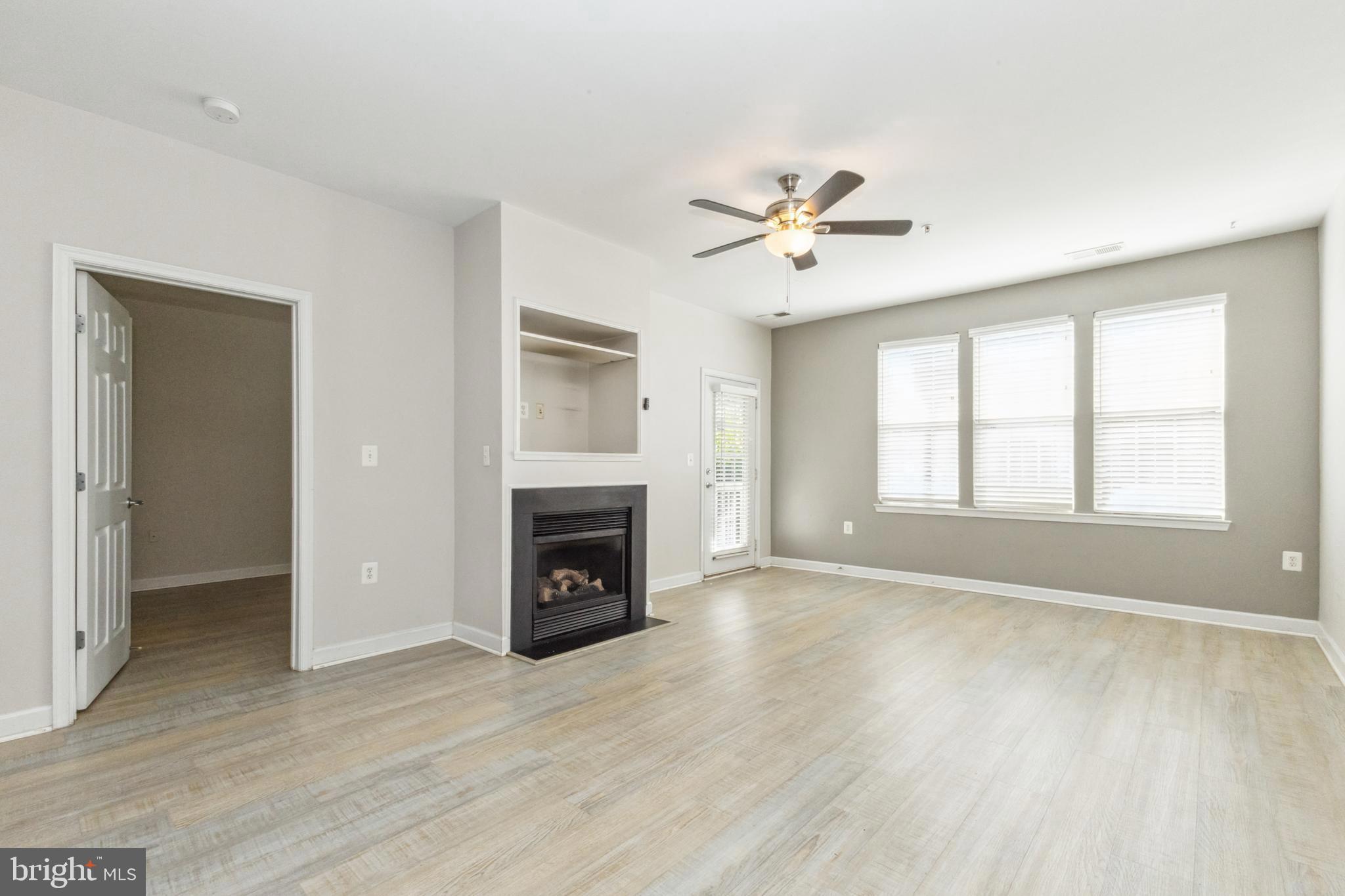 22664 Blue Elder Terrace, Unit 102 Brambleton, VA 20148 - Photo 3 of 25 a view of empty room with fireplace and wooden floor