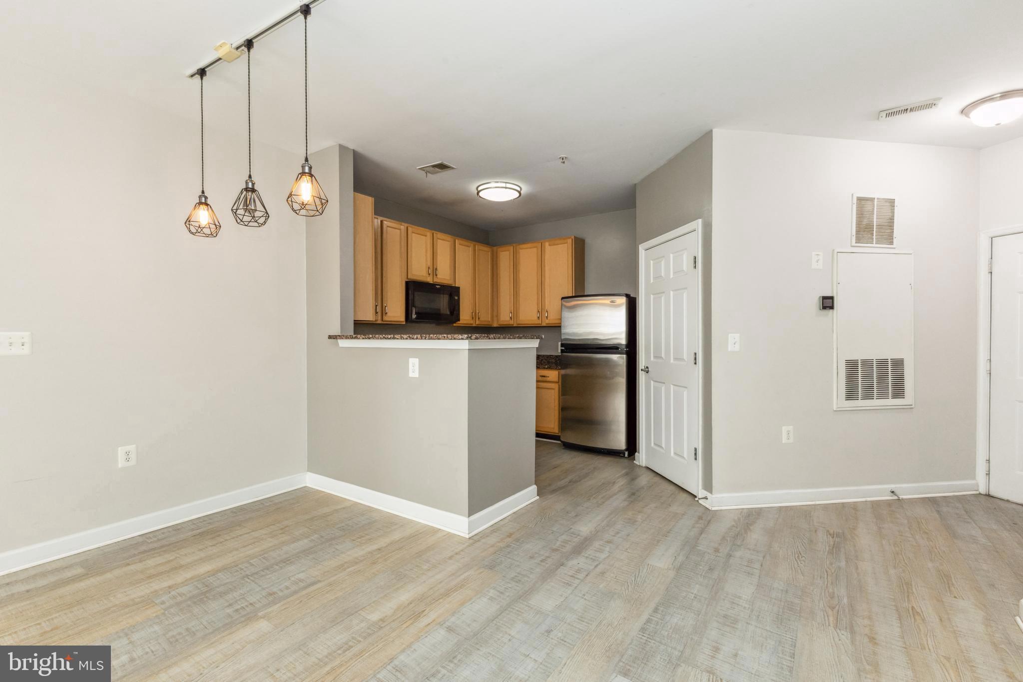 22664 Blue Elder Terrace, Unit 102 Brambleton, VA 20148 - Photo 5 of 25 a kitchen with stainless steel appliances granite countertop a refrigerator a sink and a stove