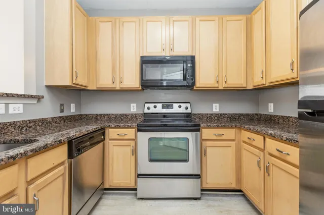 a kitchen with granite countertop white cabinets and white stainless steel appliances