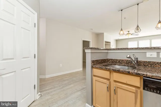 a kitchen with granite countertop a sink and cabinets