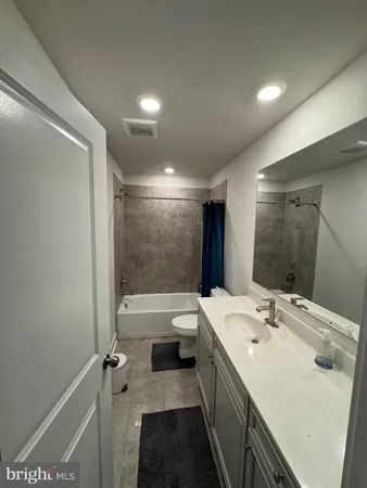 a bathroom with a double vanity sink toilet tub and shower