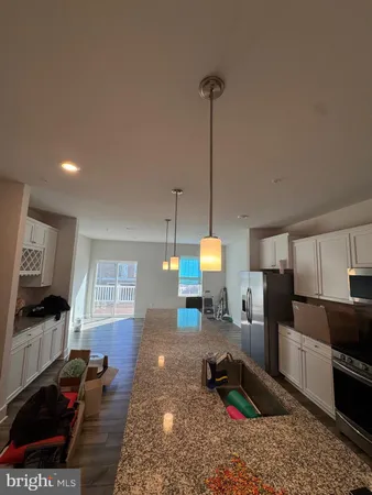 a kitchen with stainless steel appliances granite countertop a sink a stove and a wooden floors