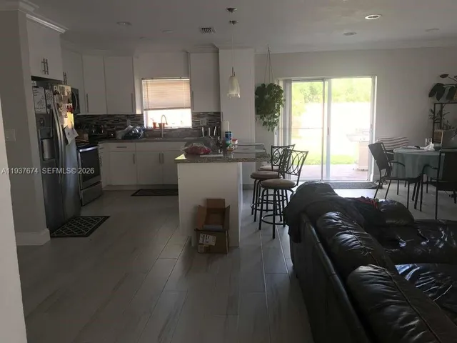 a kitchen with a table chairs refrigerator and dining table