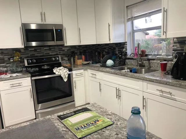 a kitchen with a stove a sink and a microwave