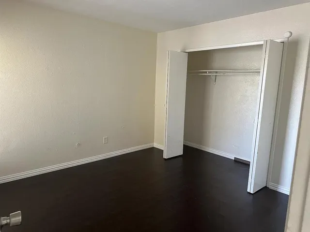 an empty room with wooden floor and closet
