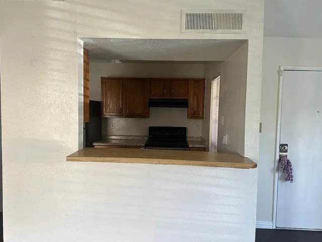 a view of kitchen with stainless steel appliances wooden floor and chair