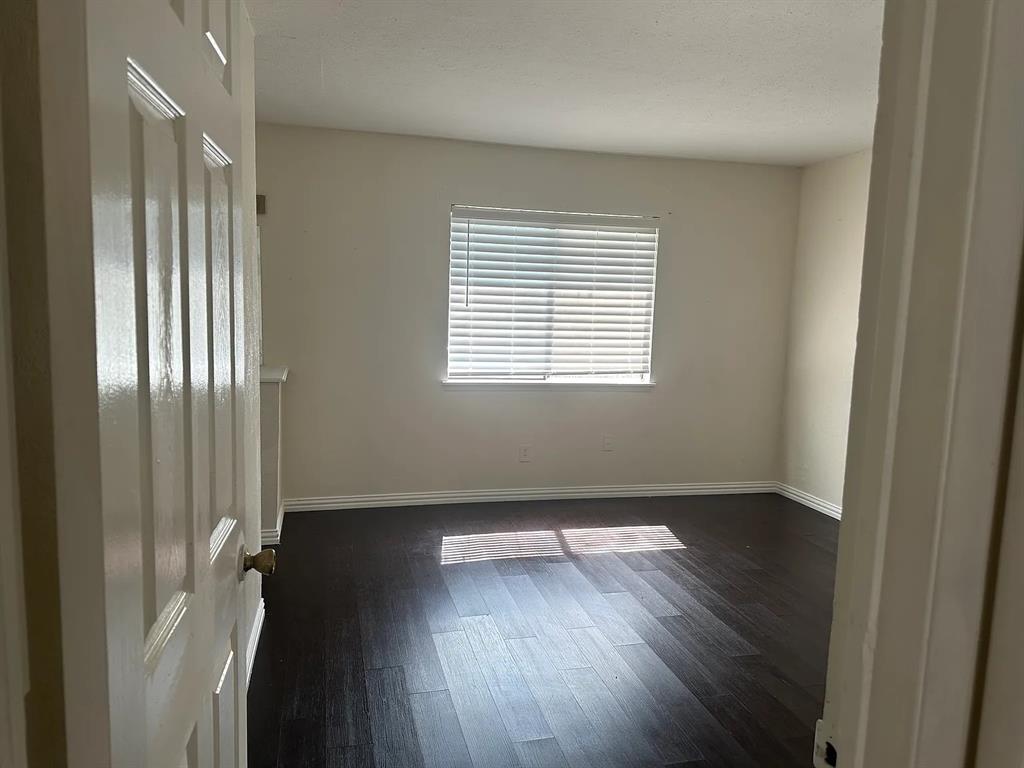 2414 Limestone Drive Arlington, TX 76014 - Photo 18 of 18 a view of an empty room with wooden floor and a window