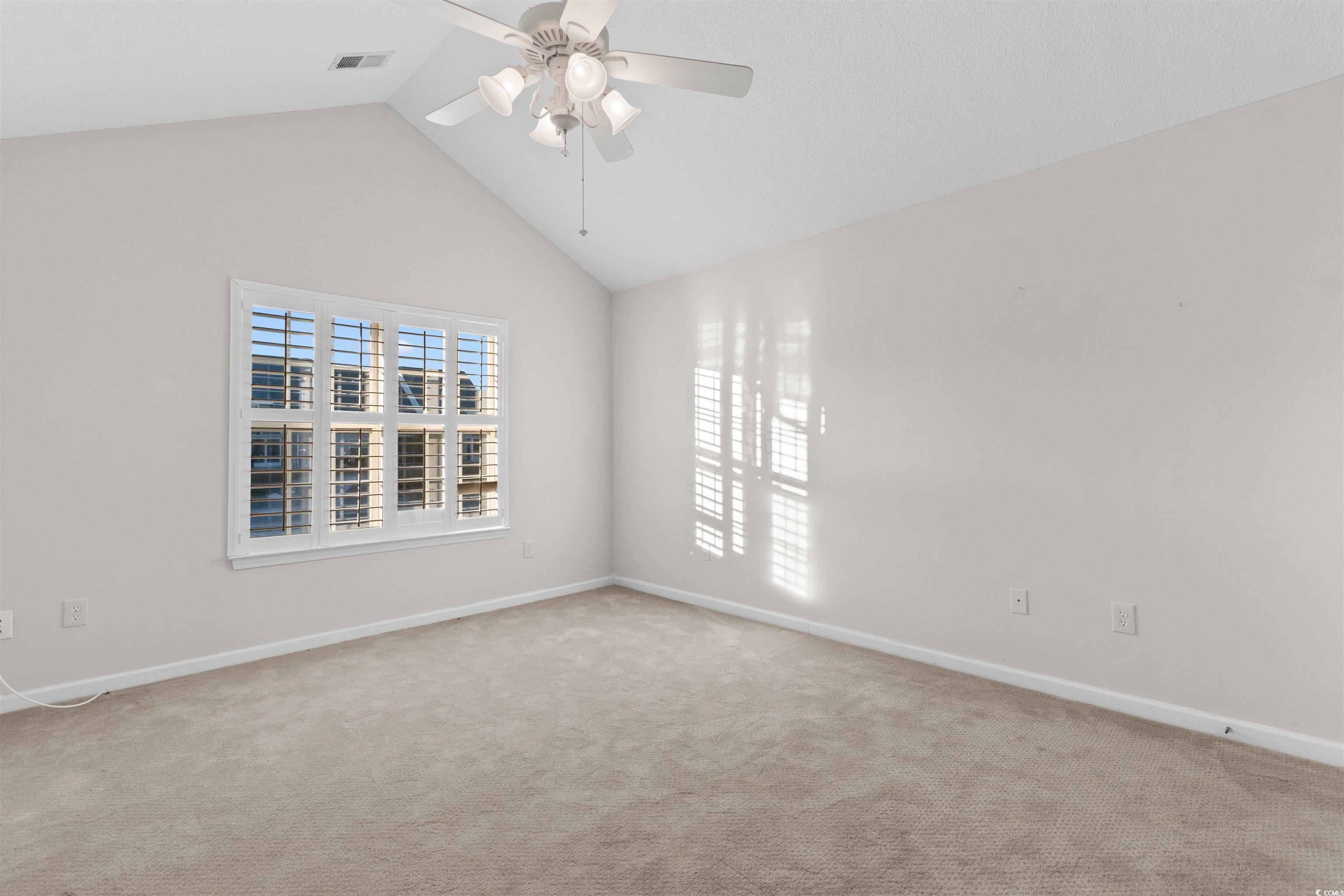 153 Wimbledon Way, Unit 153 Murrells Inlet, SC 29576 - Photo 17 of 32 Unfurnished room featuring vaulted ceiling, light colored carpet, and a ceiling fan
