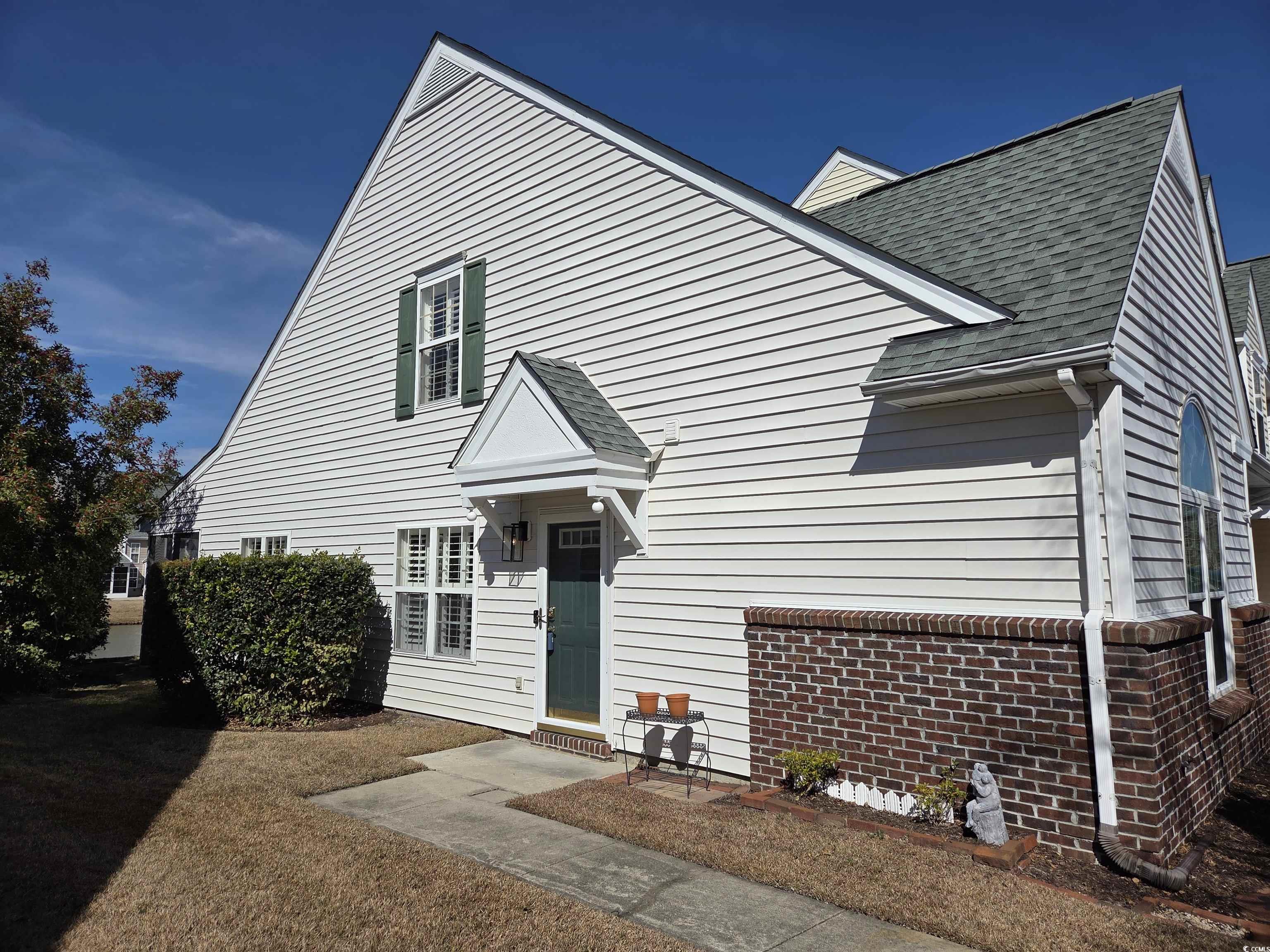 153 Wimbledon Way, Unit 153 Murrells Inlet, SC 29576 - Photo 2 of 21 View of front of house featuring a shingled roof, brick siding, a garage, and concrete driveway
