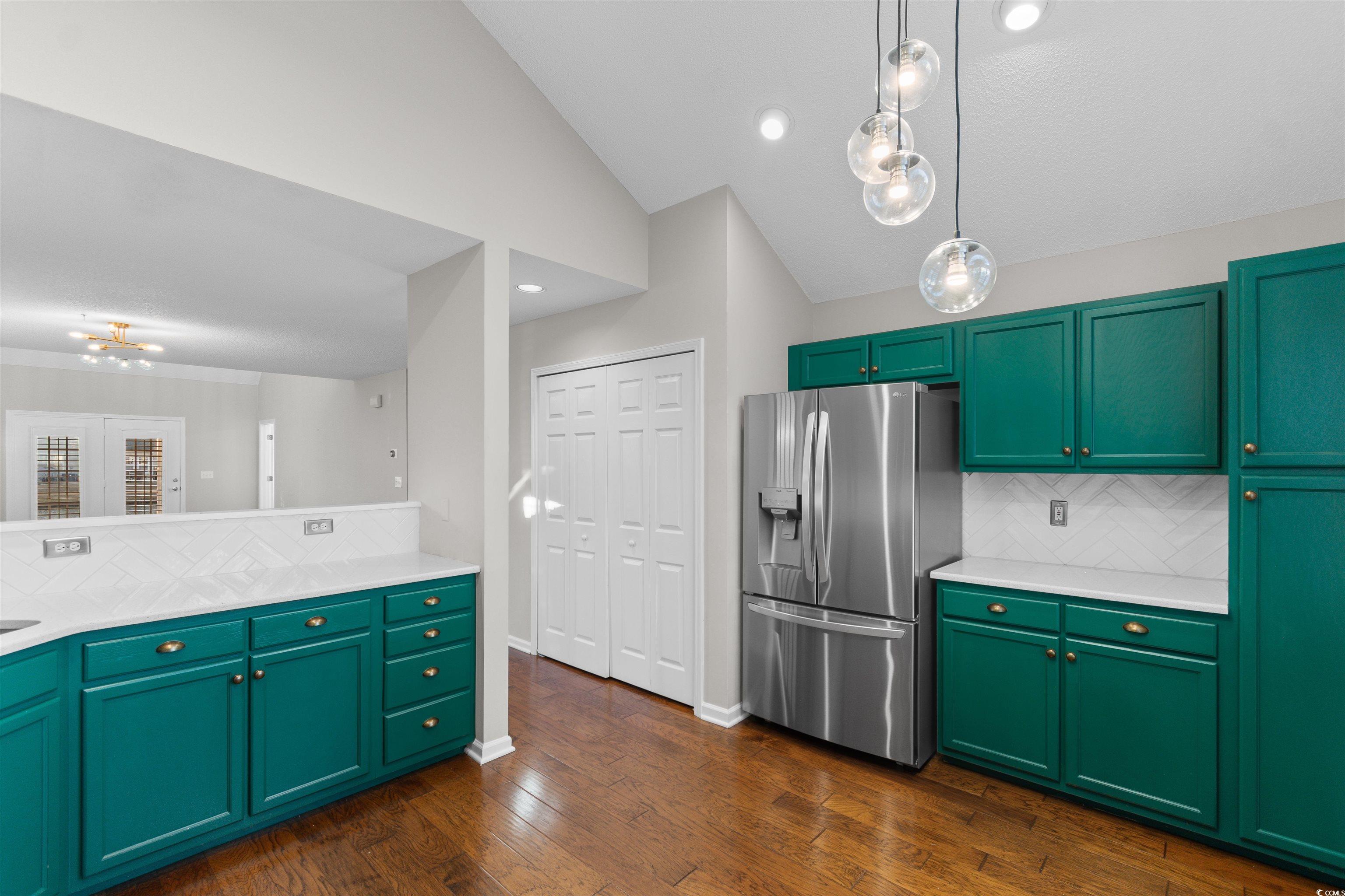 153 Wimbledon Way, Unit 153 Murrells Inlet, SC 29576 - Photo 8 of 32 Kitchen featuring green cabinets, decorative backsplash, stainless steel refrigerator with ice dispenser, hanging light fixtures, and light stone countertops