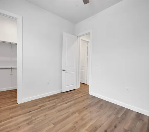 a view of an empty room with wooden floor