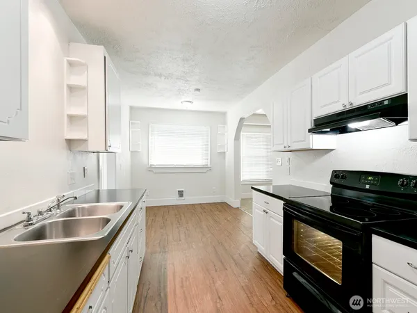 a kitchen with granite countertop a sink stove and cabinets