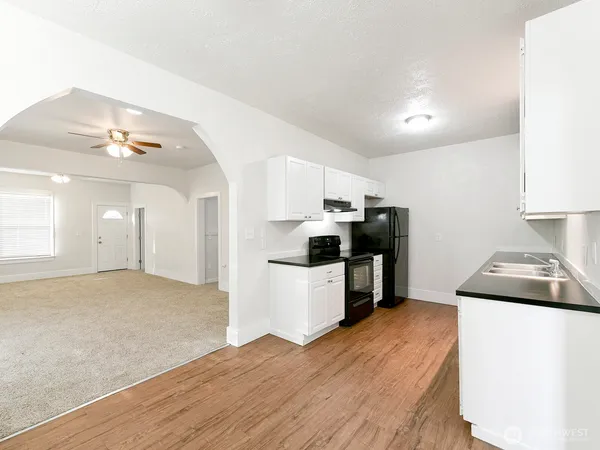 a kitchen with cabinets and wooden floor