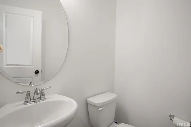 a bathroom with a sink a toilet and mirror