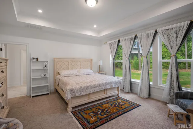 a spacious bedroom with a bed and a large window