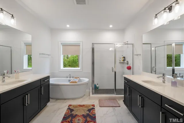 a bathroom with a double vanity sink mirror and bathtub