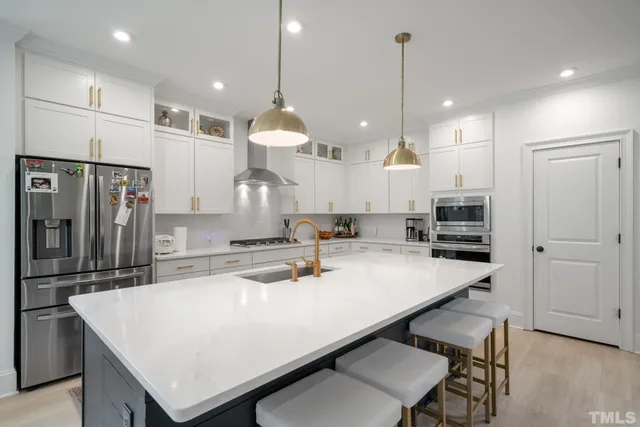 a kitchen with kitchen island a stove a refrigerator a sink and a refrigerator