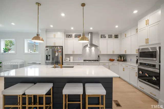 a kitchen with stainless steel appliances granite countertop a stove top oven a sink island a dining table and chairs