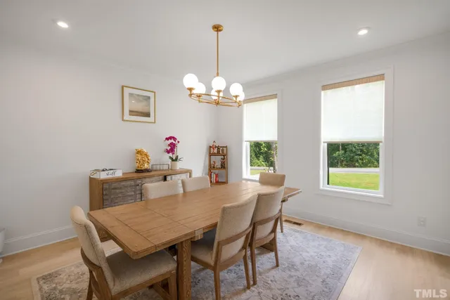 a view of a dining room with furniture a chandelier and wooden floor