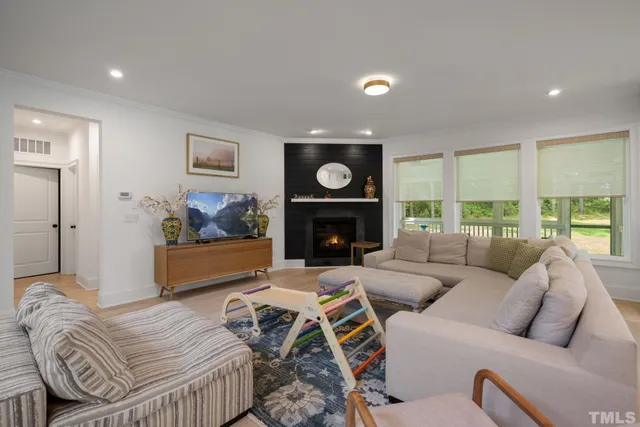 a living room with furniture a fireplace and a large window