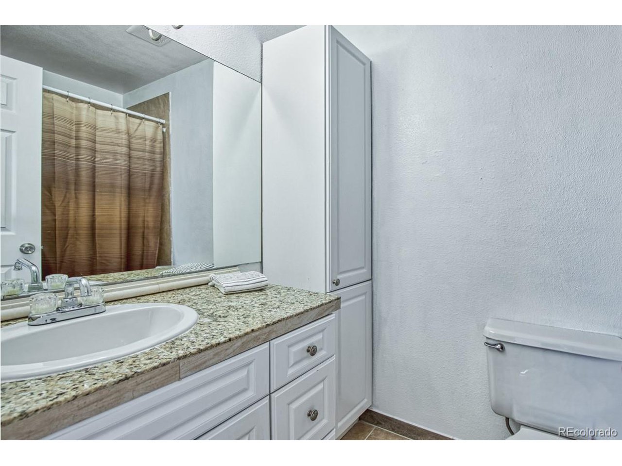 8701 Huron Street, Unit 209 Thornton, CO 80260 - Photo 11 of 25 a bathroom with a granite countertop sink and a mirror