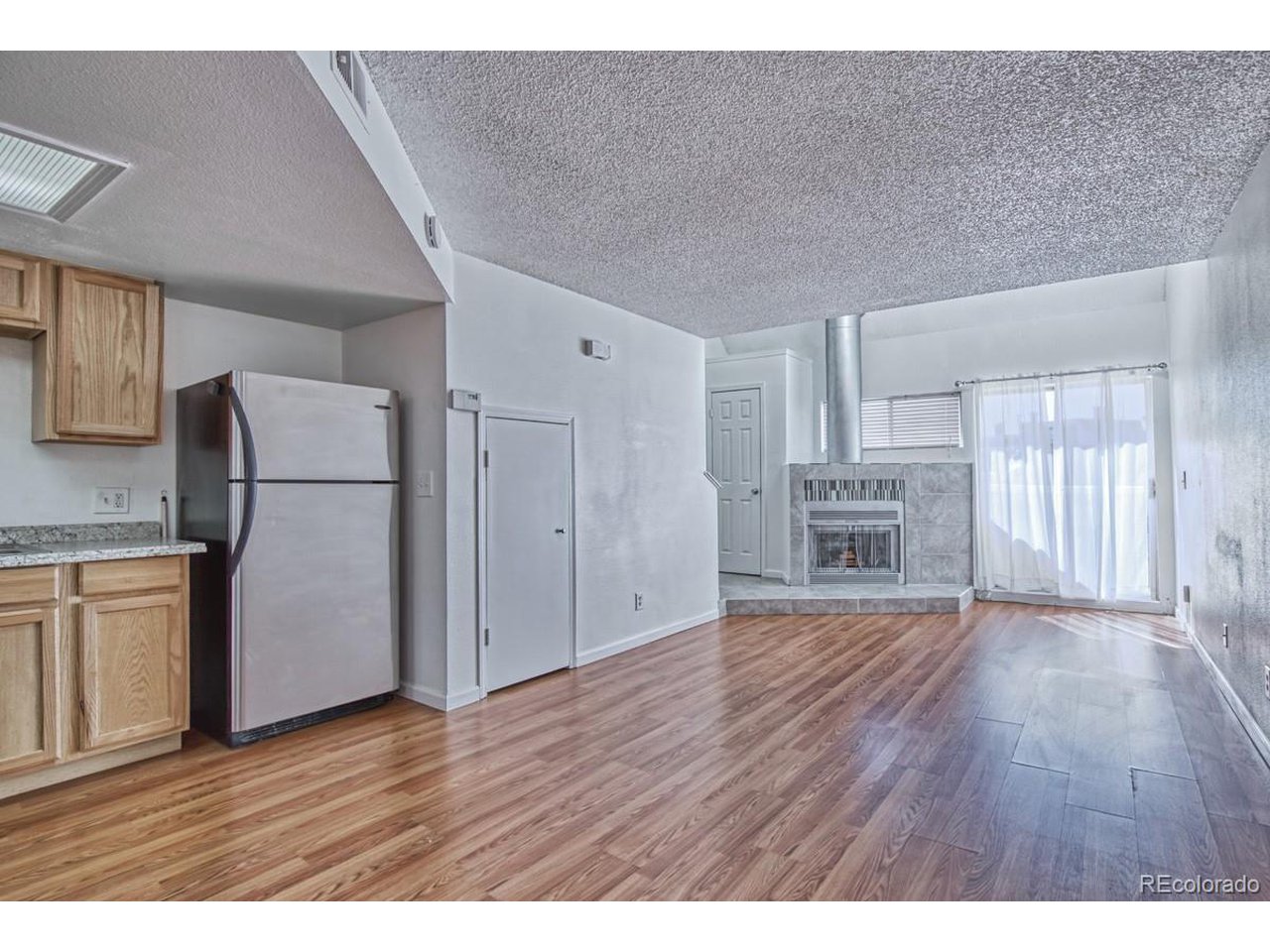 8701 Huron Street, Unit 209 Thornton, CO 80260 - Photo 5 of 25 a view of a kitchen with wooden floor and electronic appliances